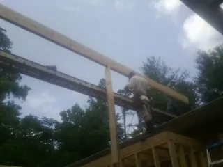 Carpenter setting a ridge beam over a new addition frame — Ice Dam Removal by Roofing Brothers in Pinopolis