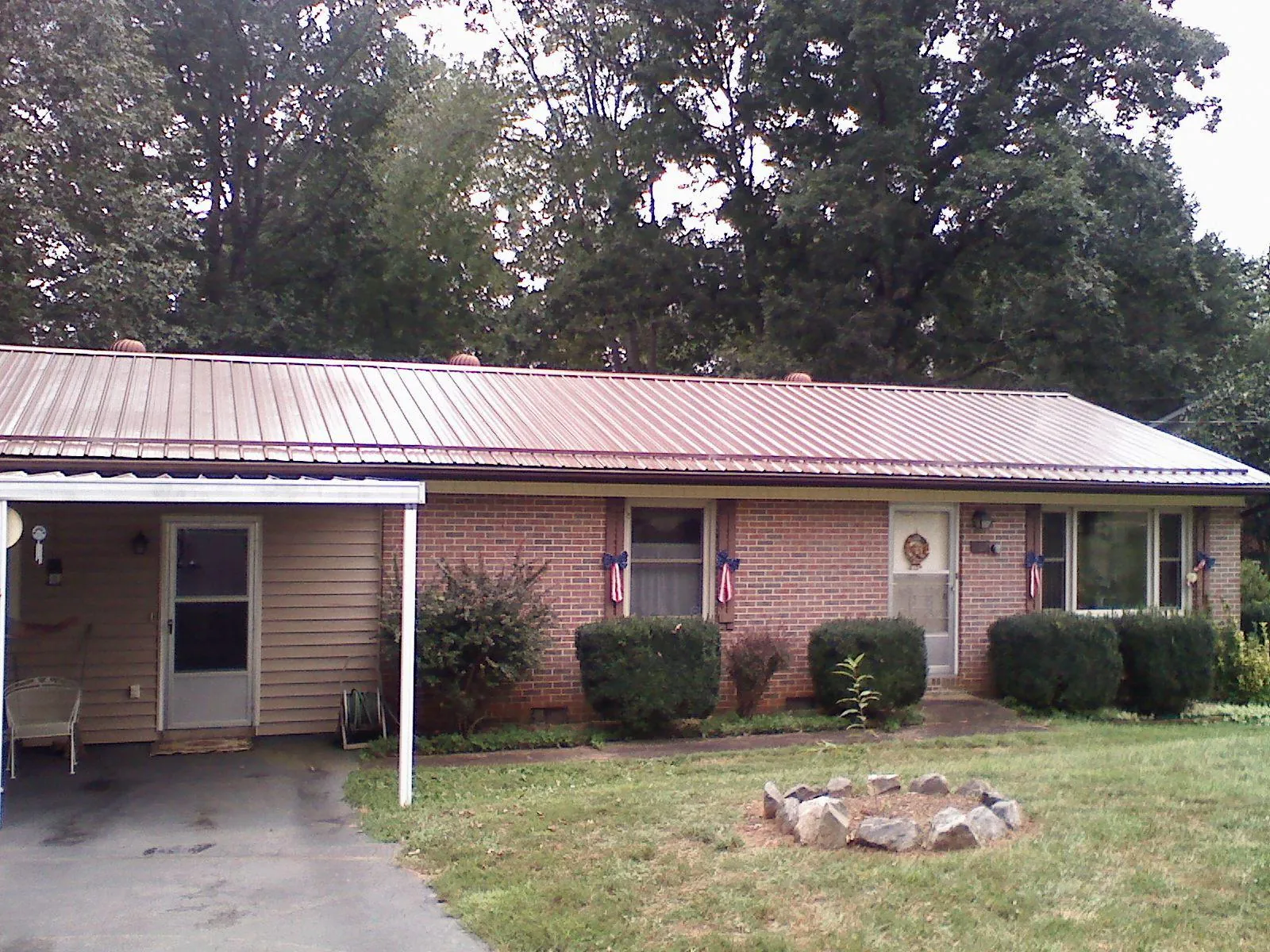 Bronze metal roof and carport on a brick ranch home — Roof Repair work by our crew in Pinopolis